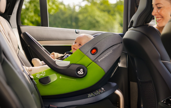 Mother looking at baby in Swandoo Albert i-Size baby car seat installed in car